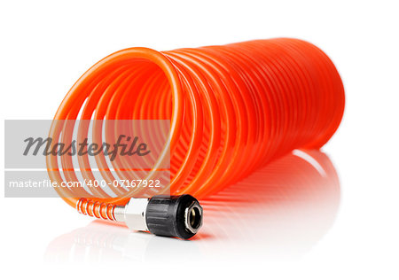 Orange red thin spiral air hose used for pneumatic tools. Isolated on white with natural reflection. Very short depth-of field, the sharpness is in the connector.