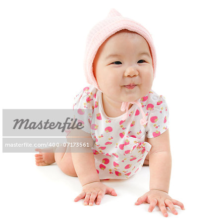 Six months old Asian mixed race baby girl crawling over white background, isolated.