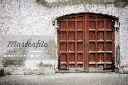 Old wooden gate in grungy gray wall