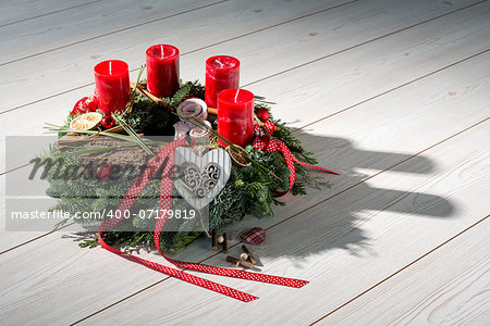 Advent wreath of twigs with red candles and various ornaments
