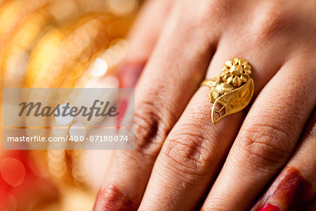 hand detail of indian bride with decorative bangle and gold ring