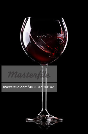 Wave of wine in wineglass on black background