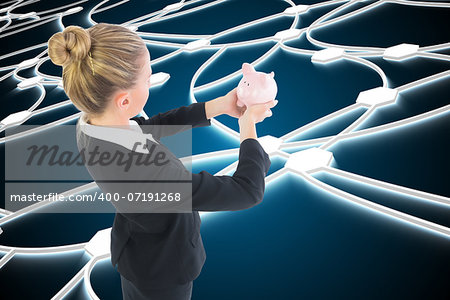 Composite image of blonde businesswoman holding pink piggy bank