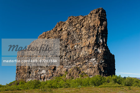 Eyjan rock in Asbyrgi. Asbyrgi is a horseshoe-shaped canyon in the national park Jokulsargljufur in the North of Iceland. The rocky walls of the canyon are up to 100 high and very steep. The canyon was probably formed during great glacial floods