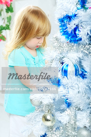 beautiful happy small girl decorate christmas tree