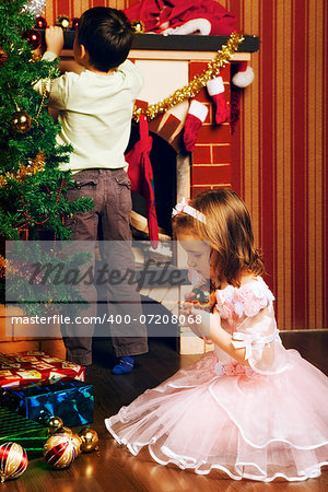 beautiful boy and girl decorate christmas tree