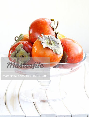 Orange ripe persimmon in a wooden table