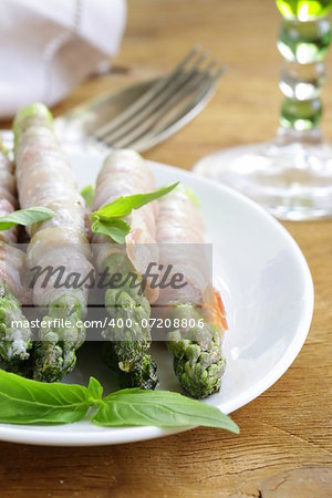 appetizer of fried asparagus with ham and basil