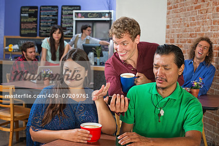 Strange man showing disgusted couple his phone