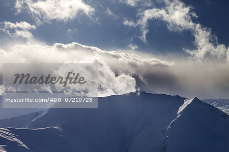 Mountains in evening and sunlit clouds. Caucasus Mountains, Georgia, view from ski resort Gudauri.