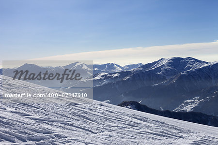 Ski slope with trace of ski, snowboards and mountains in haze. Georgia, Caucasus Mountains. Ski resort Gudauri.