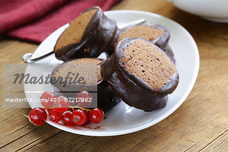 chocolate mini cakes decorated with currants on a white plate