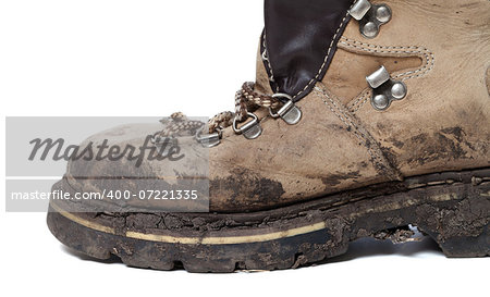 Old trekking boot in mud. Isolated on white background. Close-up view.