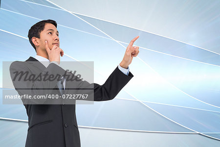 Composite image of thoughtful asian businessman pointing