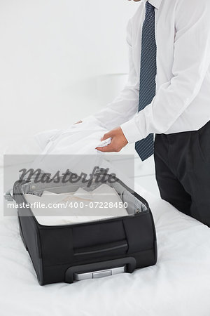 Side view mid section of a businessman unpacking luggage at a hotel bedroom
