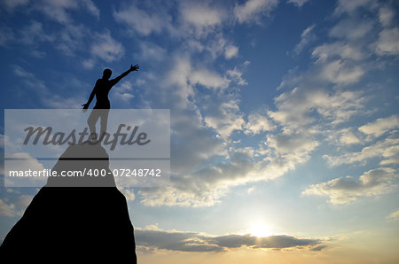 man on top of the mountain reaches for the sun