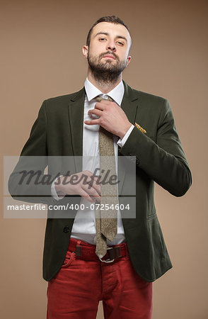 young man in a green suit and tie, beige background