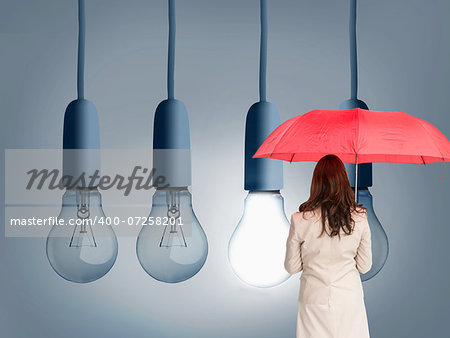 Composite image of businesswoman standing back to camera holding red umbrella against white background