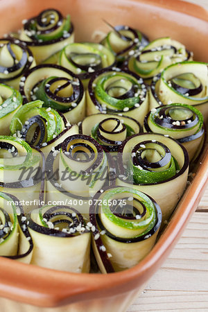 Eggplant and zucchini rolls on baking sheet with hemp seed