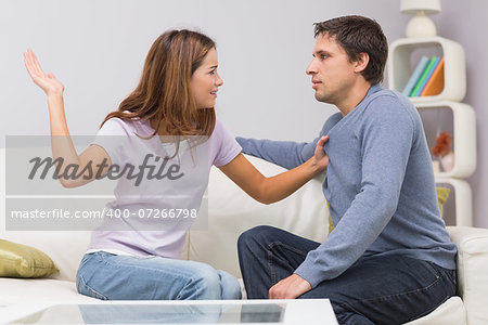 Side view of a young woman about to slap man in the living room at home