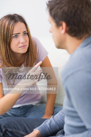 Angry young couple having an argument in their living room at home