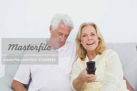 Relaxed senior couple watching television in a house