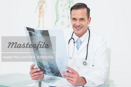 Portrait of a smiling male doctor with x-ray picture in the medical office
