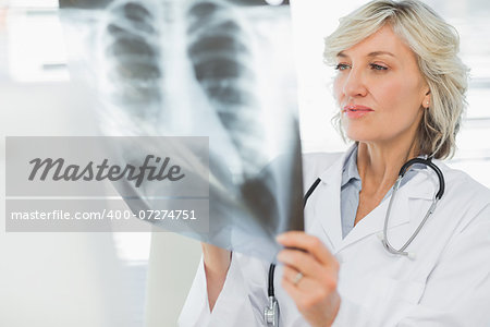 Serious female doctor examining xray in the medical office