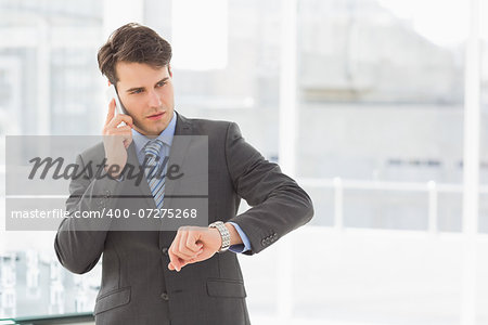 Businessman checking the time on the phone in the office