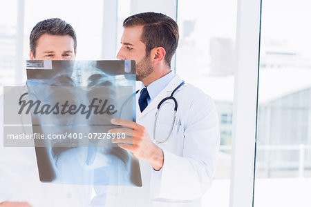 Two male doctors examining xray in a bright medical office