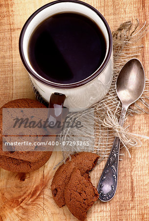 Arrangement of Rustic Cup of Black Tea with Chocolate Chip Cookies and Tea Spoon closeup on Wooden background. Top View