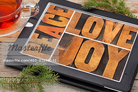 love, joy and peace word abstract on a digital tablet with a cup of tea