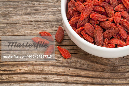 goji berries (woldberry) - white ceramic bowl on a grained wood