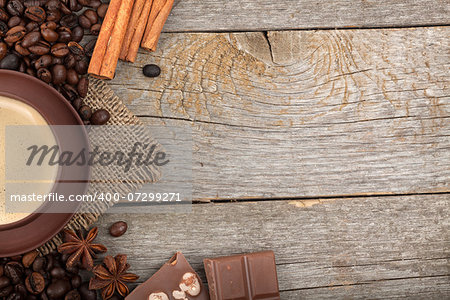 Coffee cup, spices and chocolate on wooden table texture with copy space. View from above