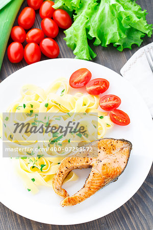 Delicious fettuccini with fried salmon on a plate