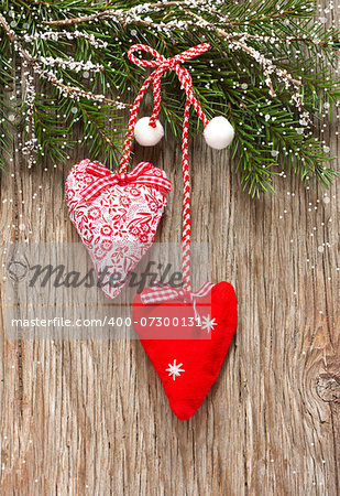 Christmas decoration with two hearts on an old wooden background with snow.