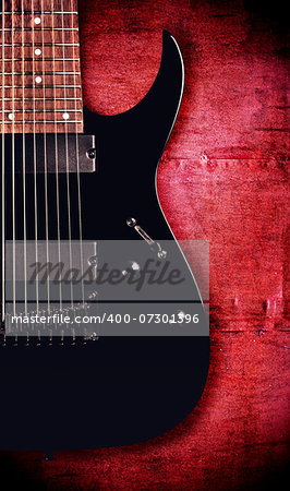 black electric eight-string guitar, painted metal background