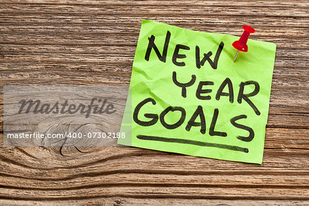 New Year goals - handwriting on a sticky note against grained wood