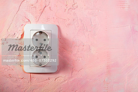 White socket on pink wall. Double socket