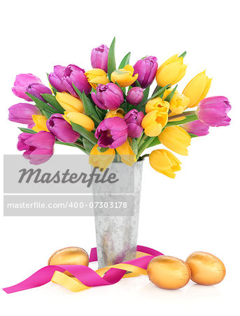 Easter eggs with tulip flower arrangement and ribbon curl over white background.