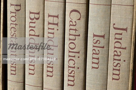Book spines listing major world religions - Judaism, Islam, Catholicism, Hinduism, Buddhism and Protestantism.