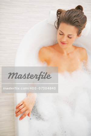 Relaxed young woman laying in bathtub