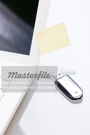 notebook laptop with post it memo and usb stick closeup macro objects office