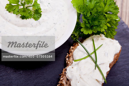 fresh tasty herbal creme cheese and bread on wooden table