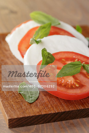 caprese salad made on wooden cutting board