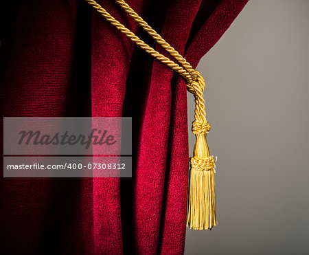 Red velvet curtain with tassel. Close up