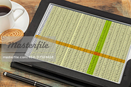 business concept - data spreadsheet on a digital tablet with a cup of coffee