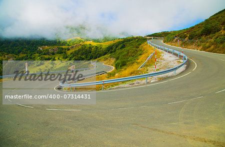 Bend in the road in the mountains in the fog