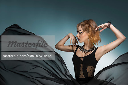 fashion portrait of bizarre dark lady with gothic style, strong make-up and rock accessories wearing and big veil flying skirt. Carnival look