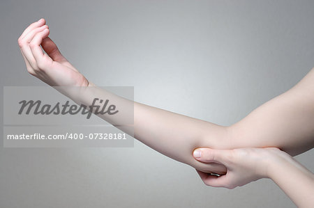 A young woman touching her painful elbow